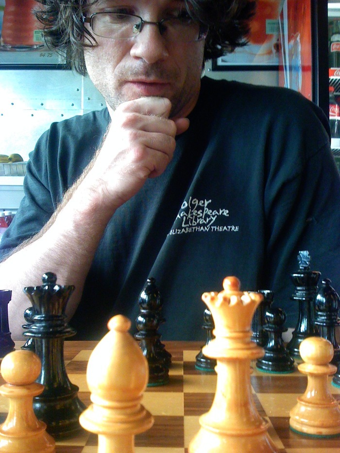 Andrew Breslin seated behind a chessboard